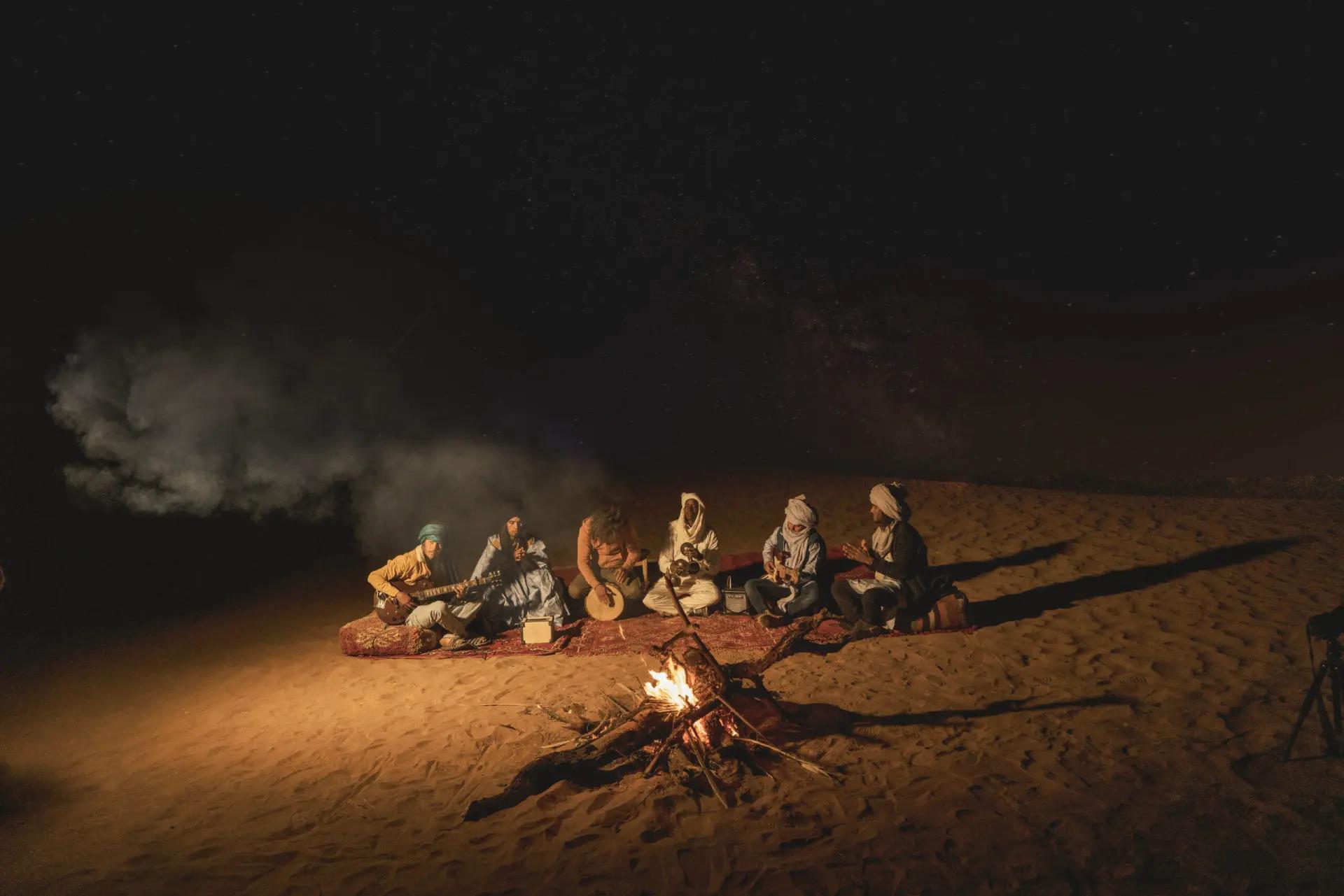 Jam-session nocturne autour du feu dans le désert de M'Hamid, sous la voie lactée