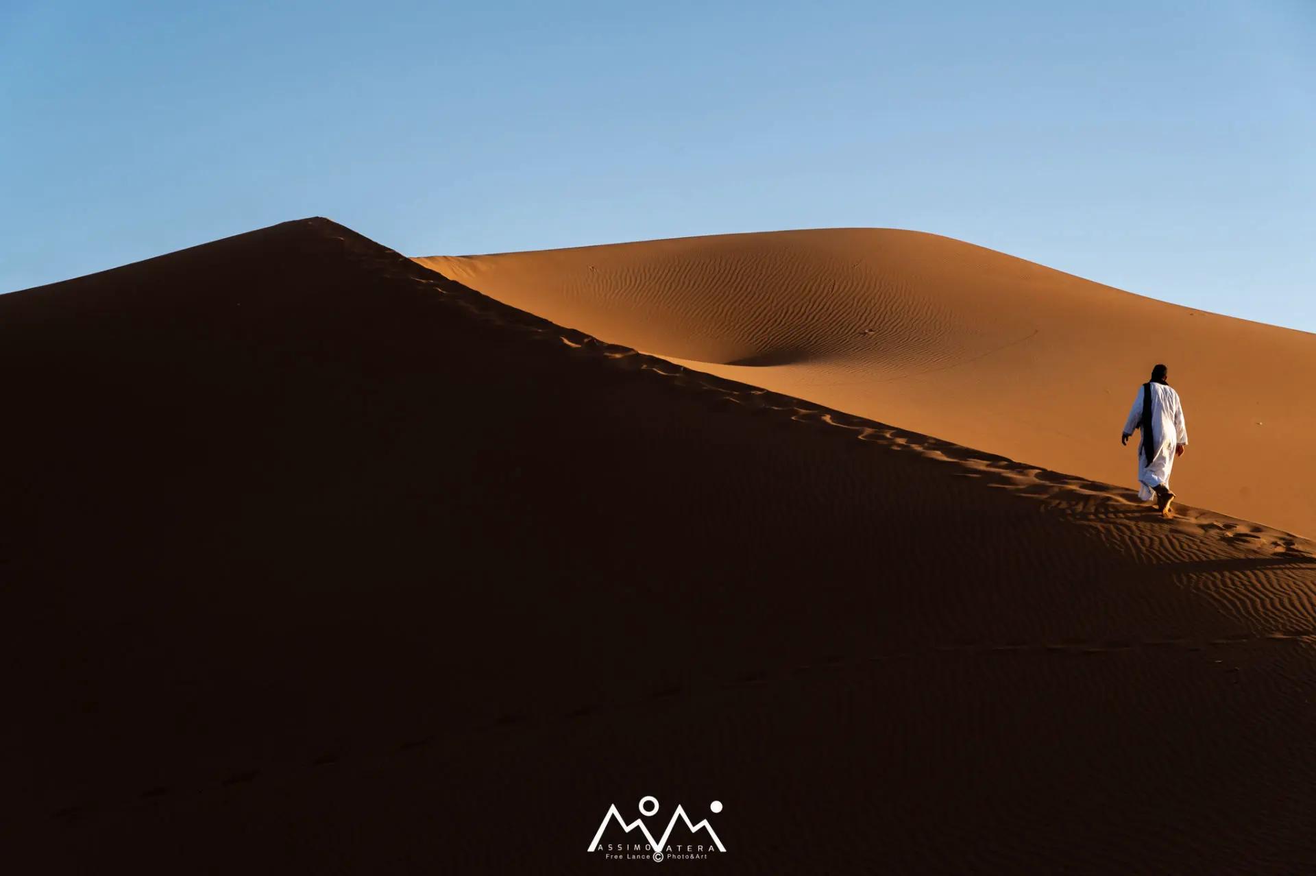 Marcheur solitaire sur la crête d'une dune du Sahara près de M'Hamid